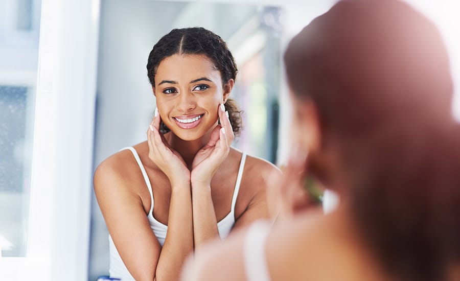 A young woman looking in the mirror​