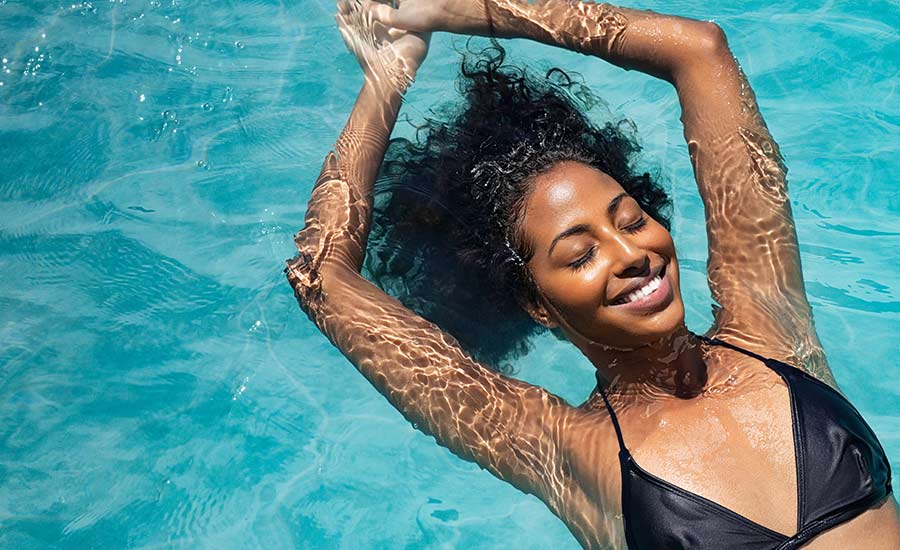 A woman smiling while floating in a pool​