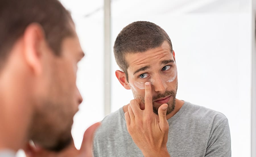 A young black man wiping his face​